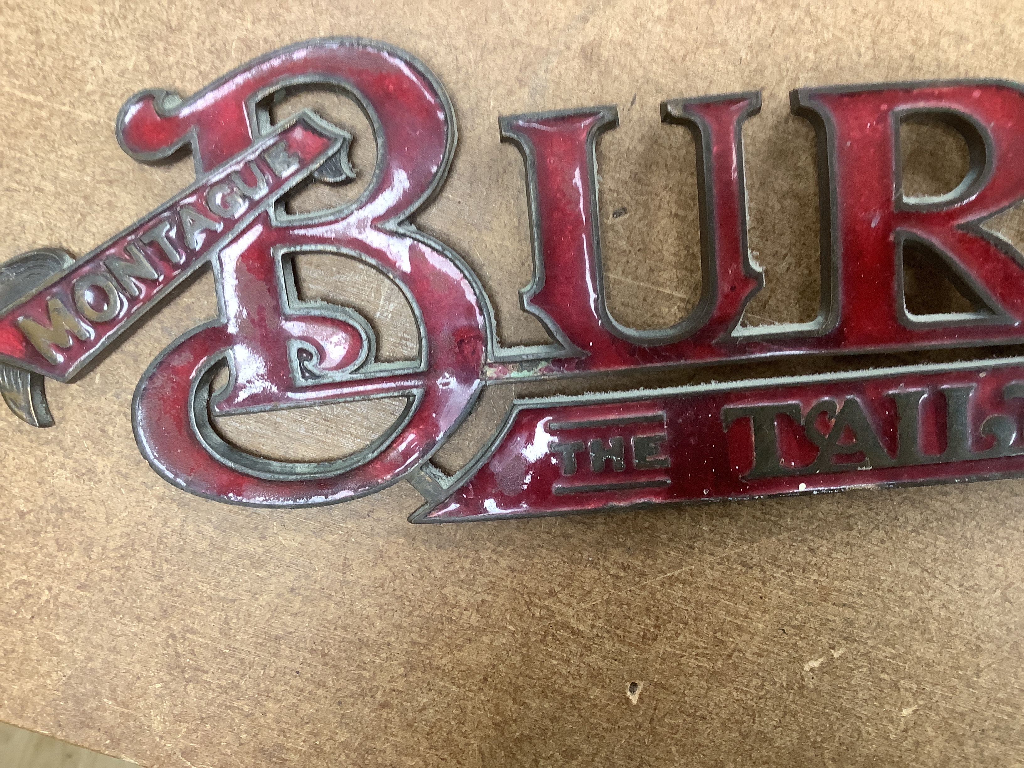 An enamelled bronze 'Montague Burton The Tailor of Taste' shop sign, 41cm wide